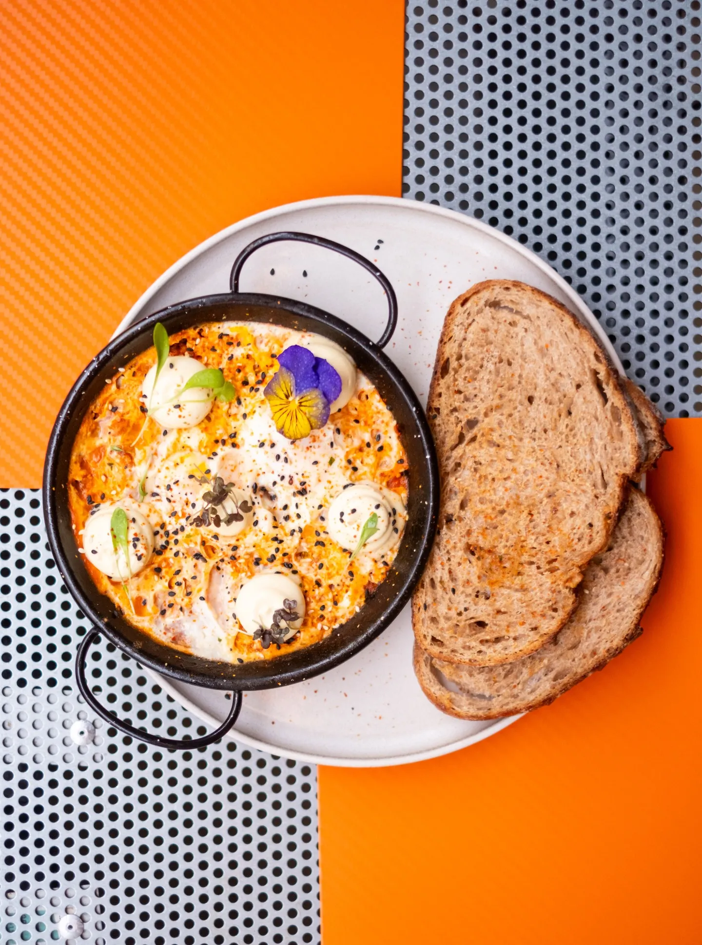 Shakshuka da Comum, numa frigideira, com pão de massa mãe
